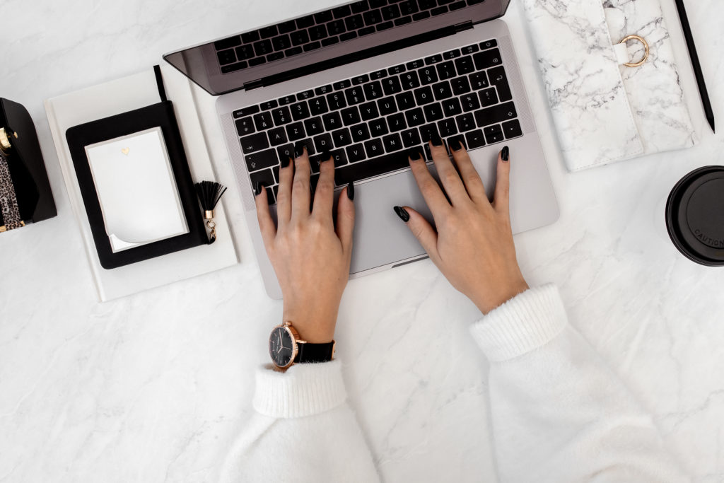 a shot of female hands placed on a Macbook